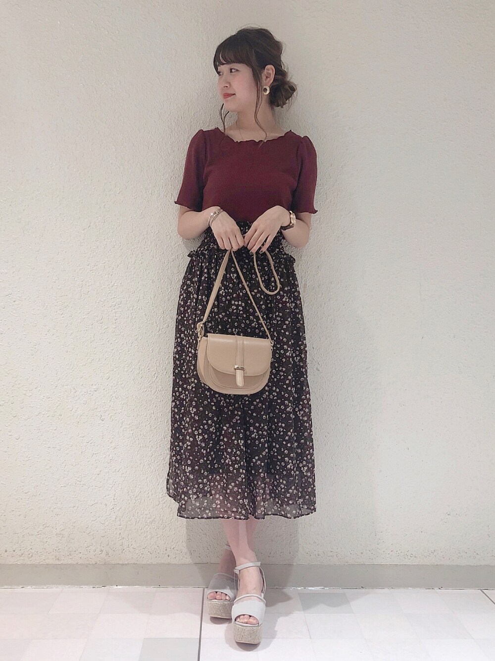 レッド系のTシャツ/カットソー、ブラウン系のスカート、ベージュ系のショルダーバッグを着用したレディースの春コーディネートの1枚目の写真