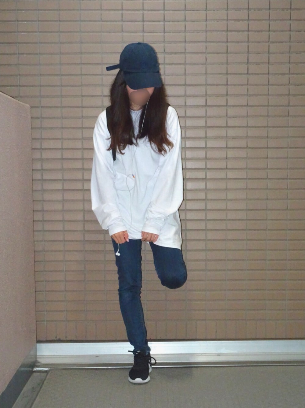 ホワイト系のTシャツ/カットソー、ブルー系のデニムパンツ、ブラック系のスニーカーを着用したレディースの春コーディネートの1枚目の写真