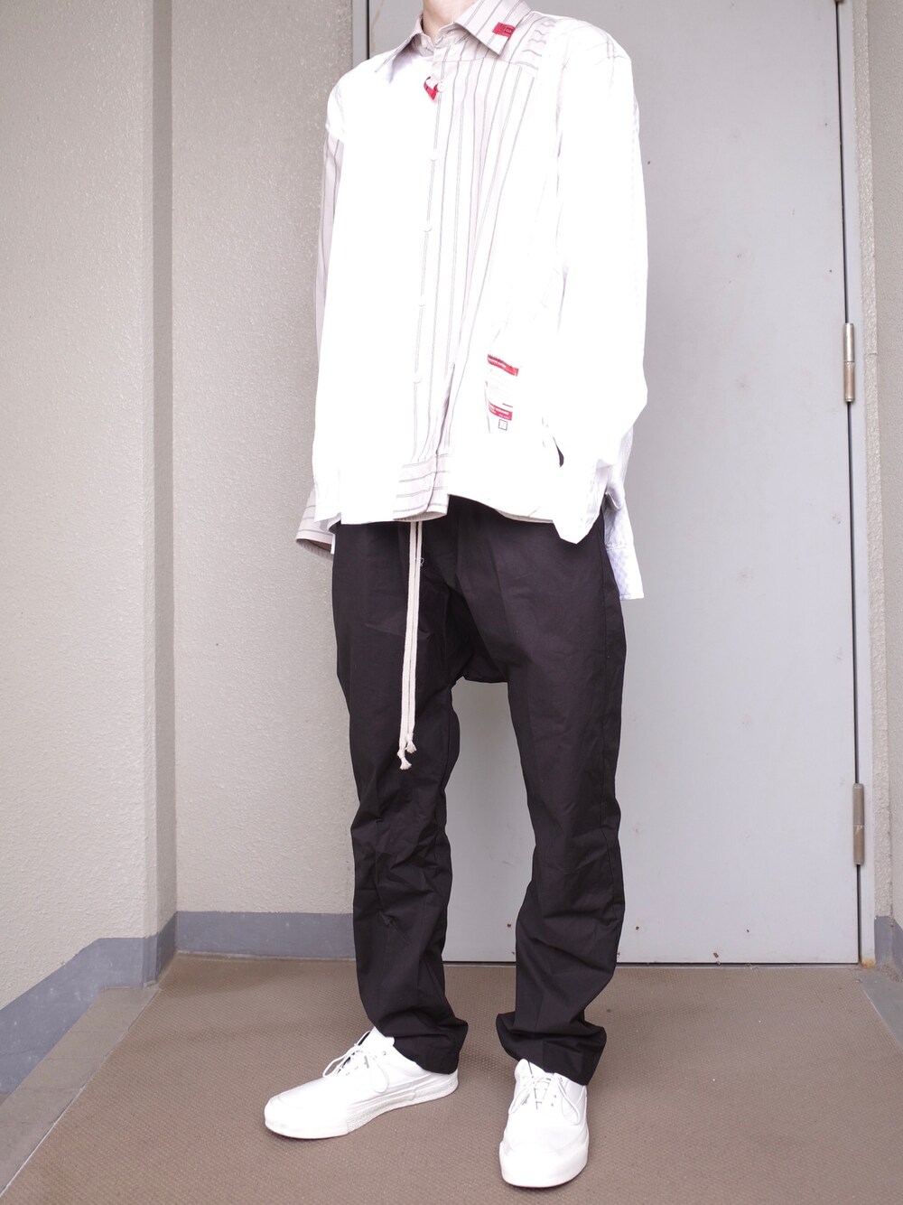 ホワイト系のシャツ/ブラウス、ブラック系のパンツ、ホワイト系のスニーカーを着用したメンズの春コーディネートの1枚目の写真