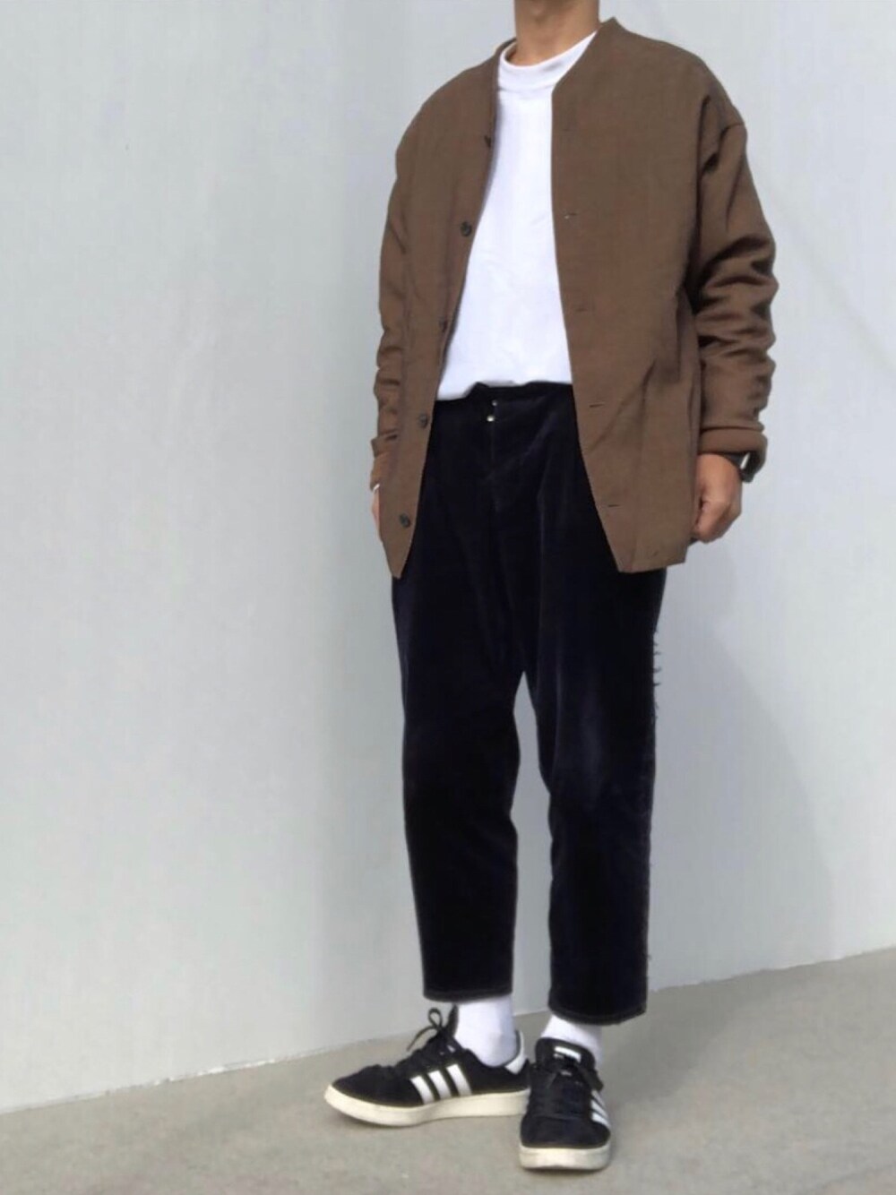 ブルー系のパンツ、ブラック系のスニーカー、ホワイト系のTシャツ/カットソーを着用したメンズの冬コーディネートの1枚目の写真