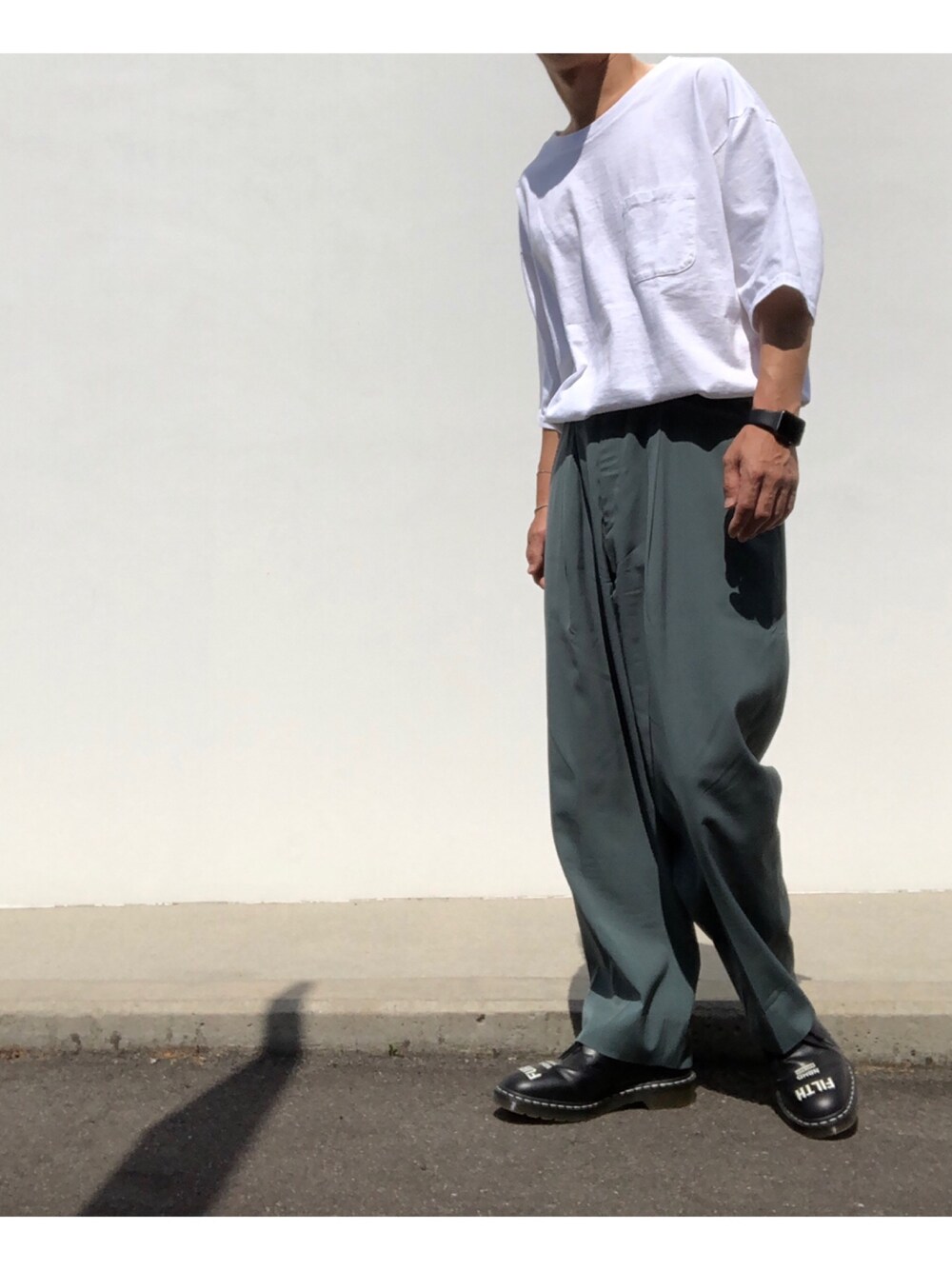 ホワイト系のTシャツ/カットソー、グリーン系のパンツ、ブラック系のシューズを着用したメンズの春コーディネートの1枚目の写真