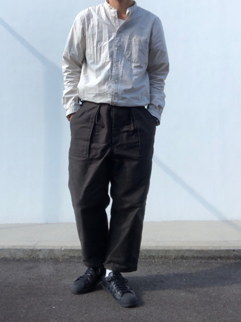 グリーン系のパンツ、ブラック系のスニーカーを着用したメンズの秋コーディネートの1枚目の写真