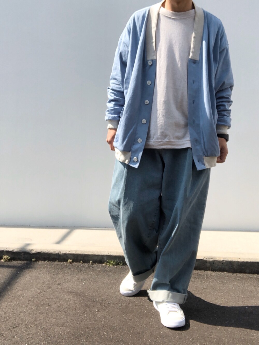 ベージュ系のTシャツ/カットソー、ブルー系のカーディガン/ボレロ、ブルー系のデニムパンツを着用したメンズの春コーディネートの1枚目の写真