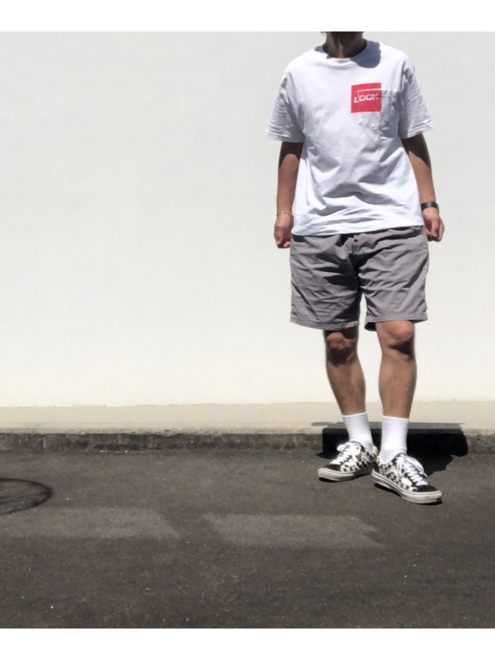 ホワイト系のTシャツ/カットソー、グレー系のパンツ、ホワイト系のスニーカーを着用したメンズの夏コーディネートの1枚目の写真