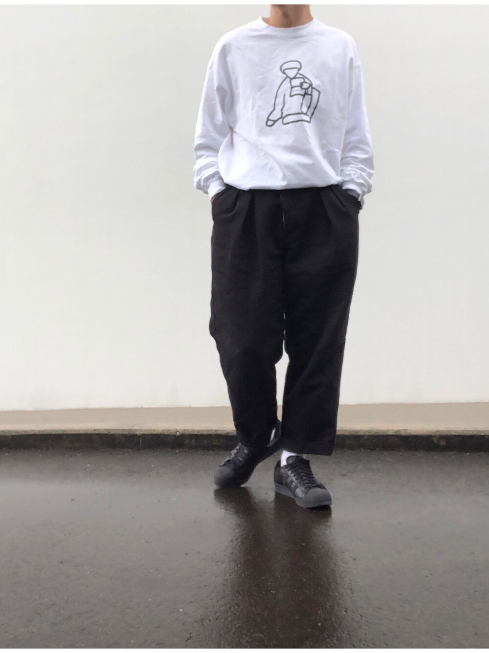 ホワイト系のTシャツ/カットソー、ブルー系のスラックス、ブラック系のスニーカーを着用したメンズの秋コーディネートの1枚目の写真