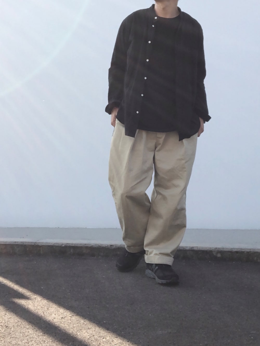 ブラック系のTシャツ/カットソー、ブラック系のシャツ/ブラウス、ベージュ系のチノパンツを着用したメンズの秋コーディネートの1枚目の写真