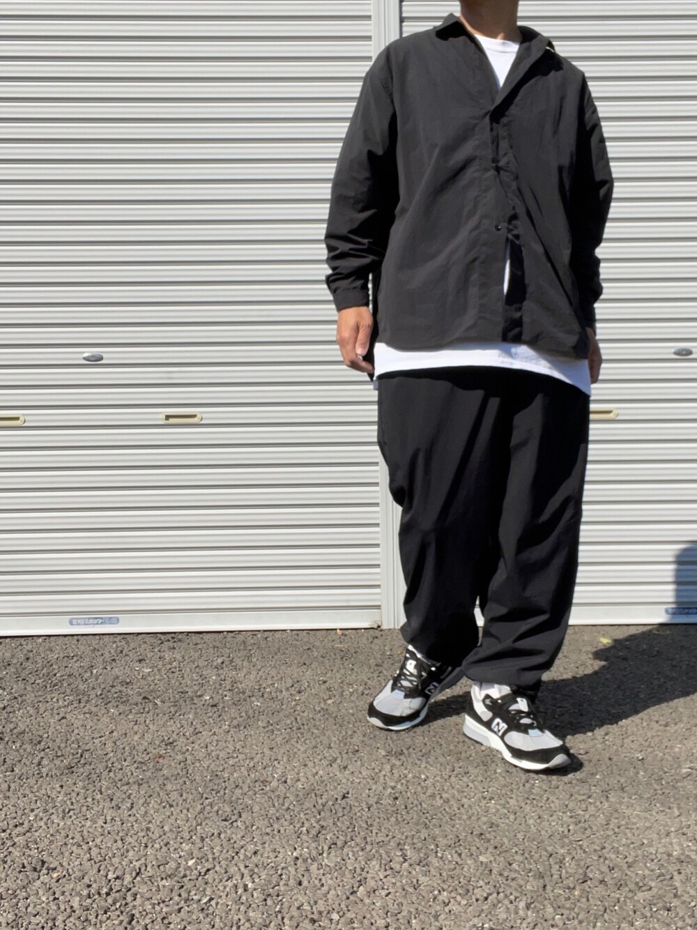 「so nakameguro、COMOLI、セットアップ、トラックパンツ、ナイロンパンツ、オールブラック、ワントーンコーデ、ブラックコーデ、ニューバランス991.5、モノトーン」｜「COMOLIのアイテム（Tシャツ/カットソー、ホワイト系）」を使った、hellocoordinateさん（メンズ・170cm）の冬コーディネートの1枚目の写真