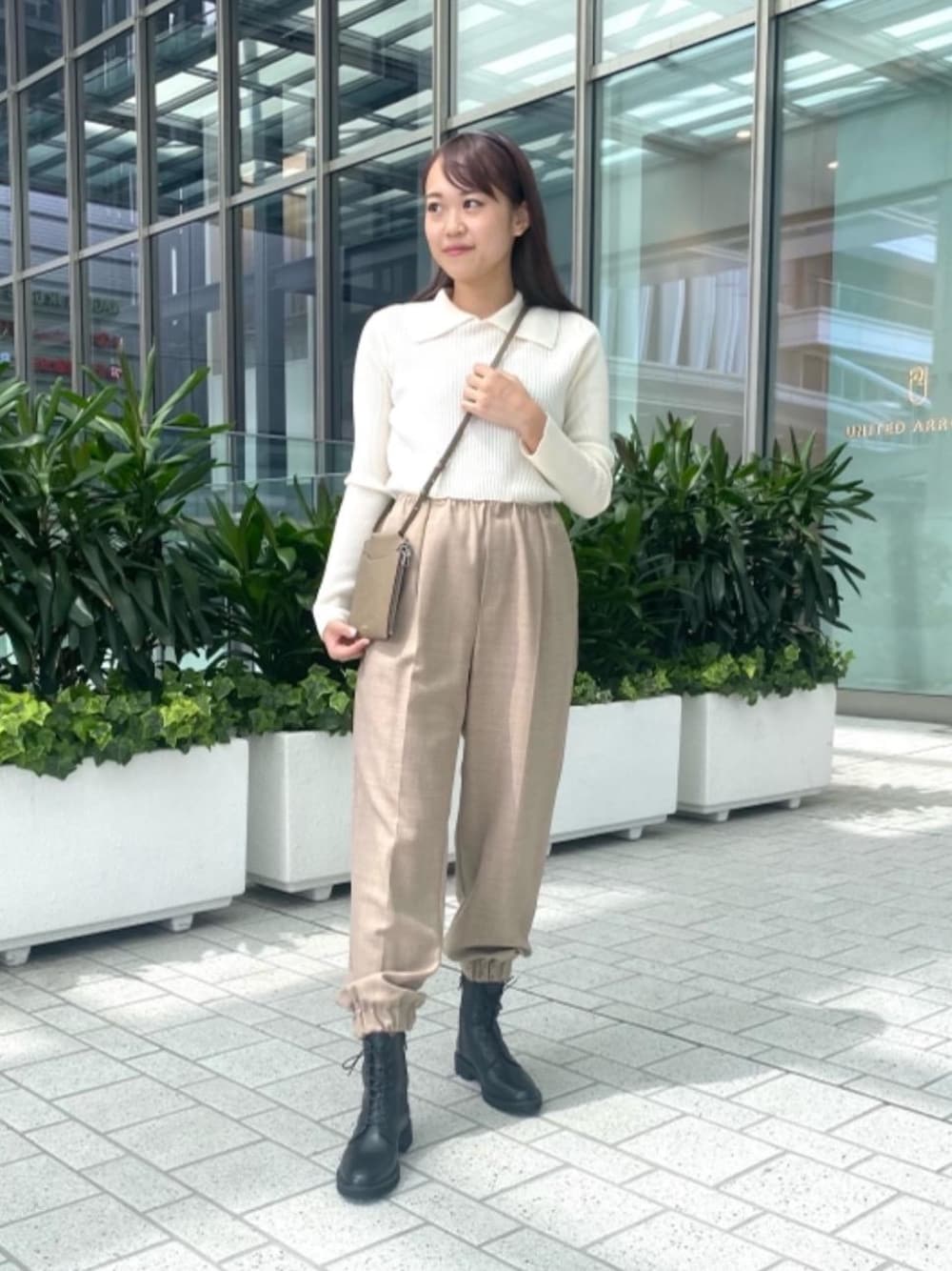 ベージュ系のその他パンツ、ブラック系のブーツ、ホワイト系のニット/セーターを着用したレディースの秋コーディネートの1枚目の写真