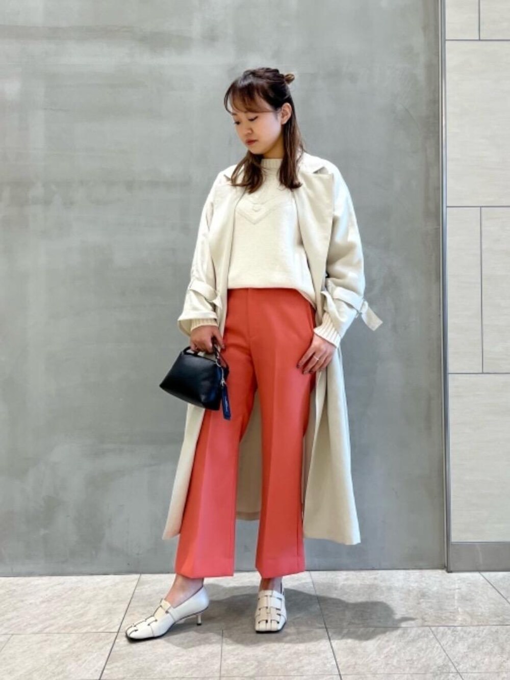 ブラック系のショルダーバッグ、オレンジ系のその他パンツ、ホワイト系のニット/セーターを着用したレディースの冬コーディネートの1枚目の写真