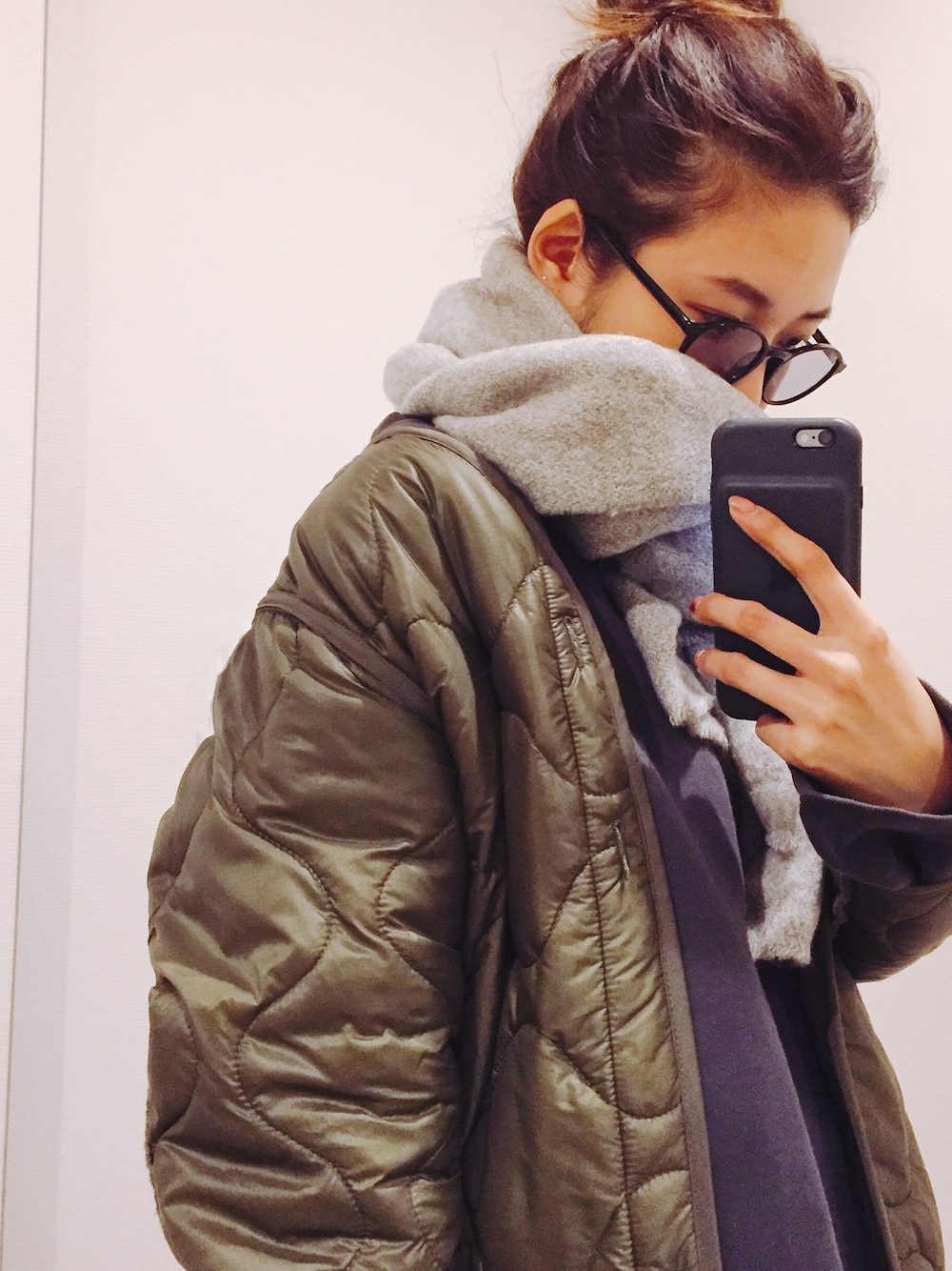 グリーン系のミリタリージャケット、ベージュ系のストール/ショールを着用したレディースの冬コーディネートの1枚目の写真