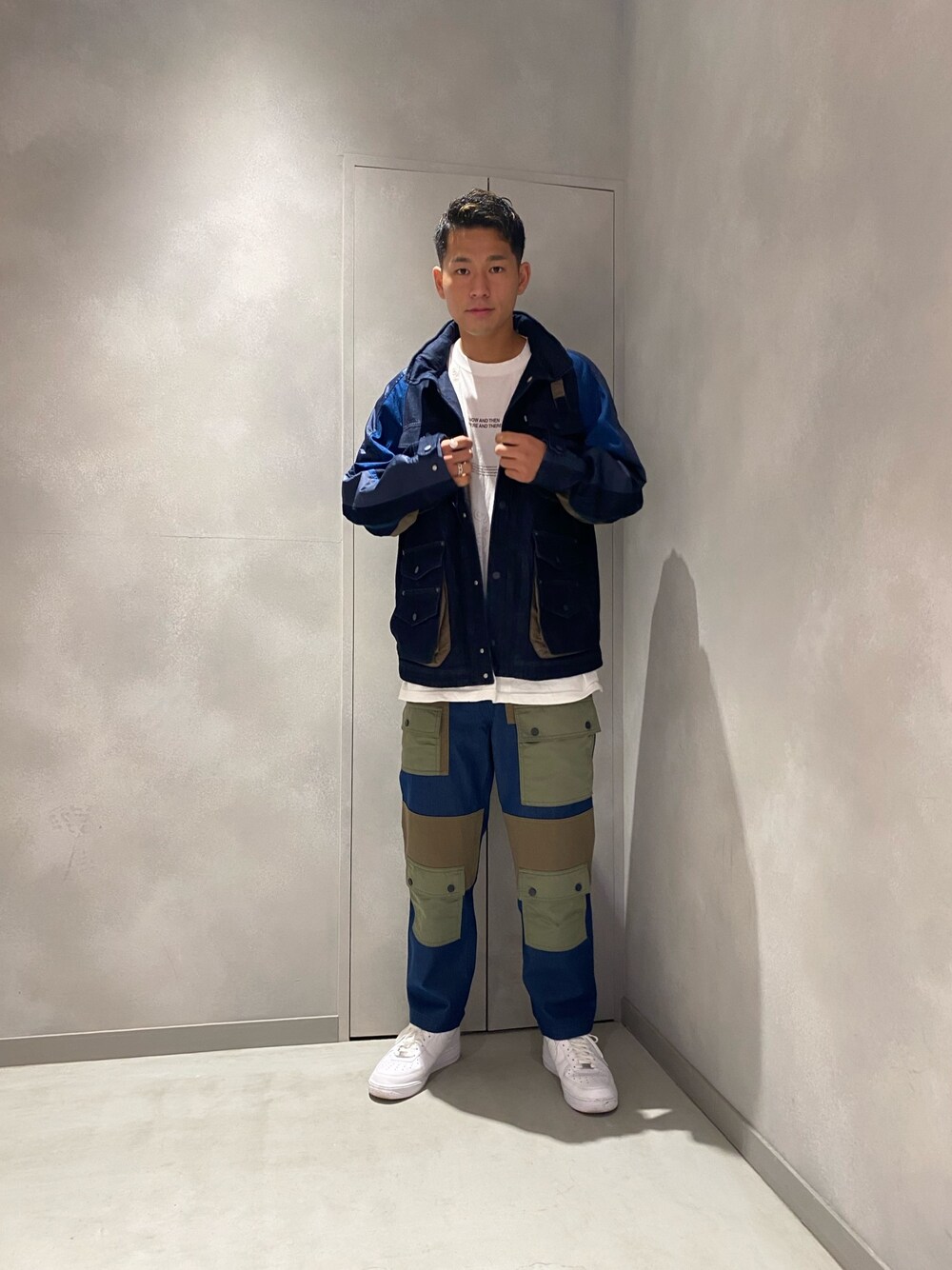 ブルー系のミリタリージャケット、ブルー系のカーゴパンツ、ホワイト系のスニーカーを着用したメンズの冬コーディネートの1枚目の写真