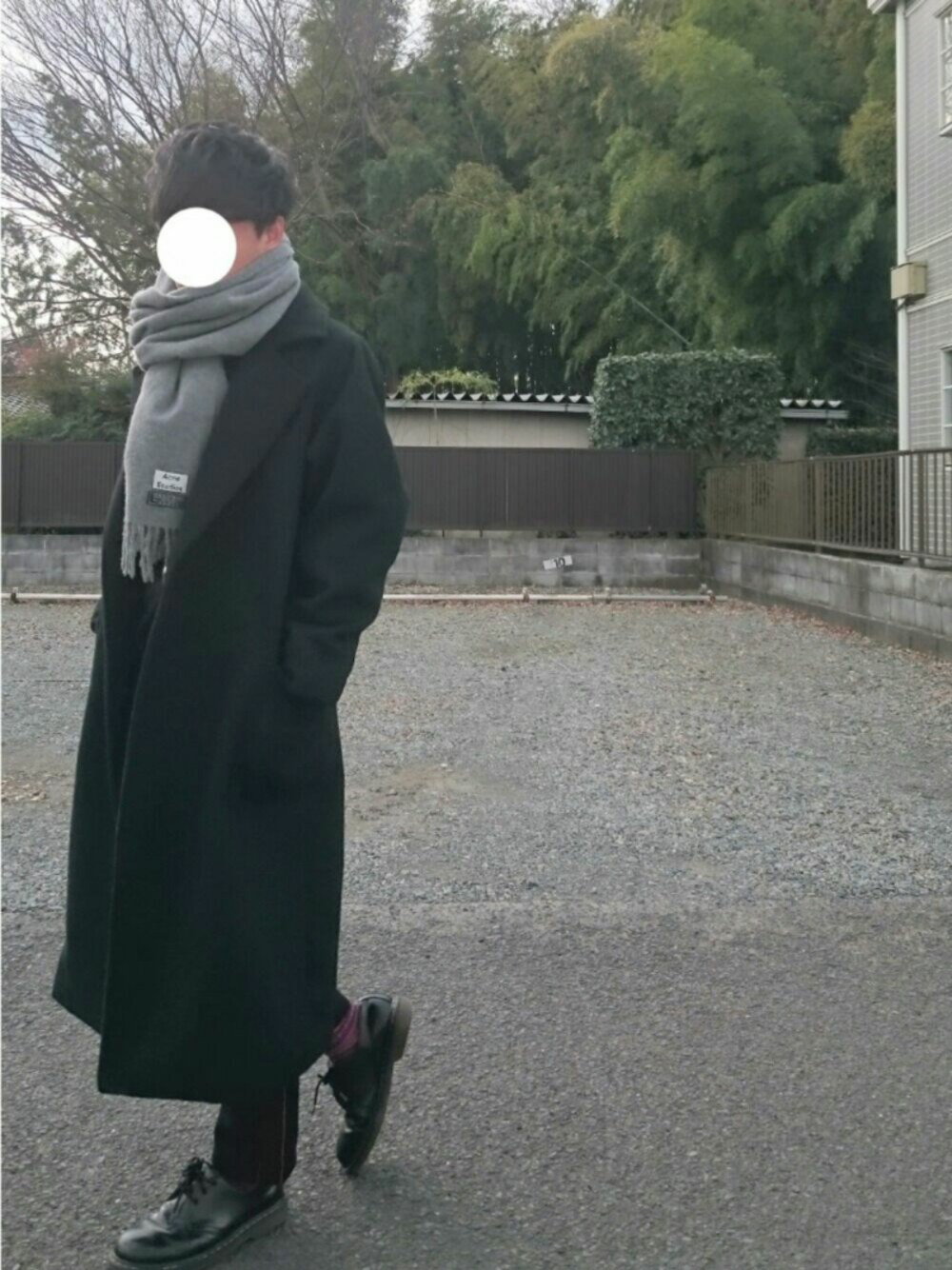 ブラック系のパンツ、ブラック系のチェスターコート、ブラック系のブーツを着用したメンズの冬コーディネートの1枚目の写真