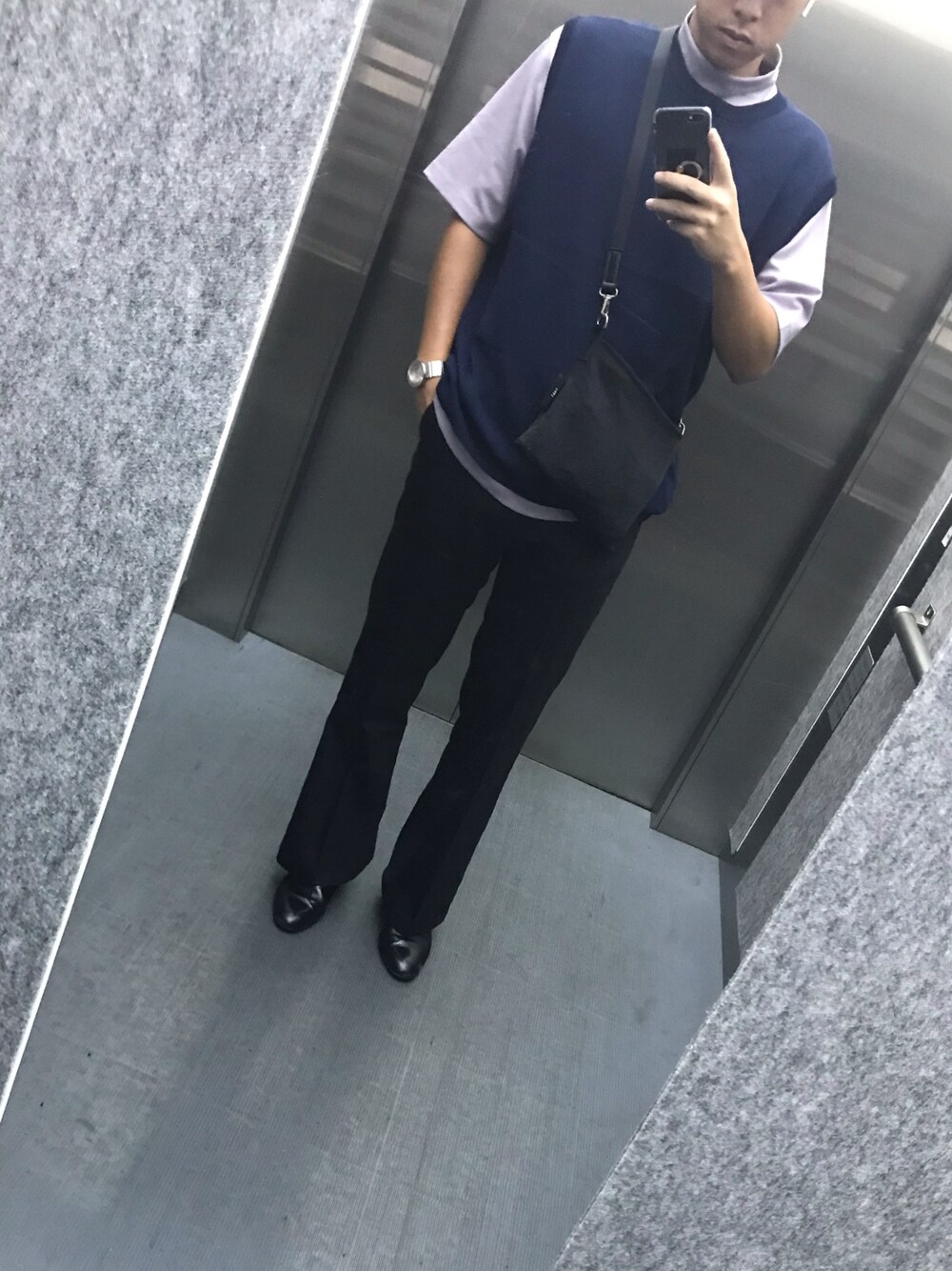 ブラック系のスラックス、パープル系のTシャツ/カットソー、ブルー系のベストを着用したメンズの秋コーディネートの1枚目の写真