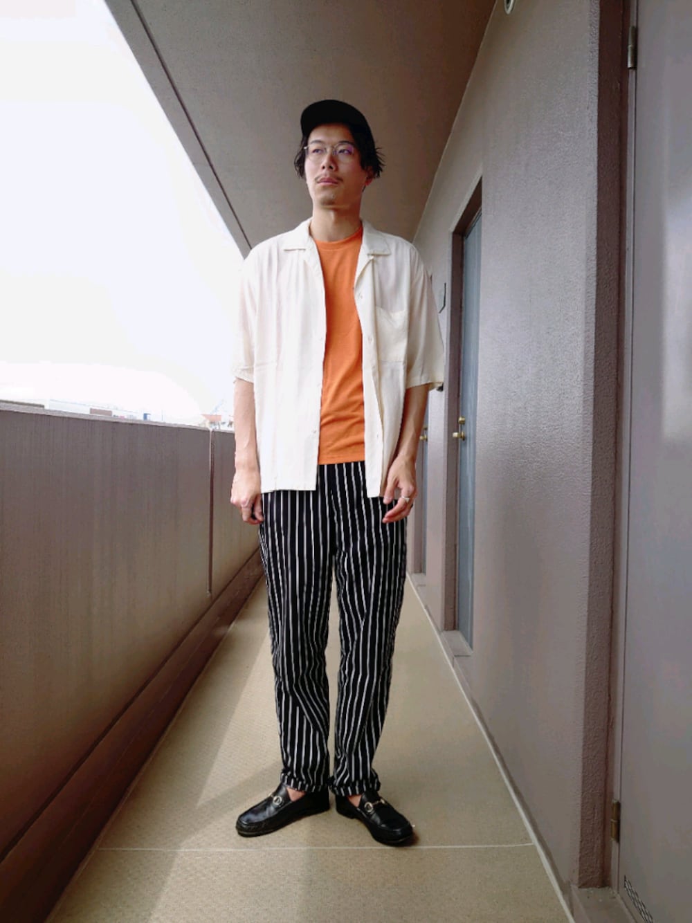 オレンジ系のTシャツ/カットソー、ホワイト系のシャツ/ブラウス、ブラック系のその他パンツを着用したメンズの春コーディネートの1枚目の写真