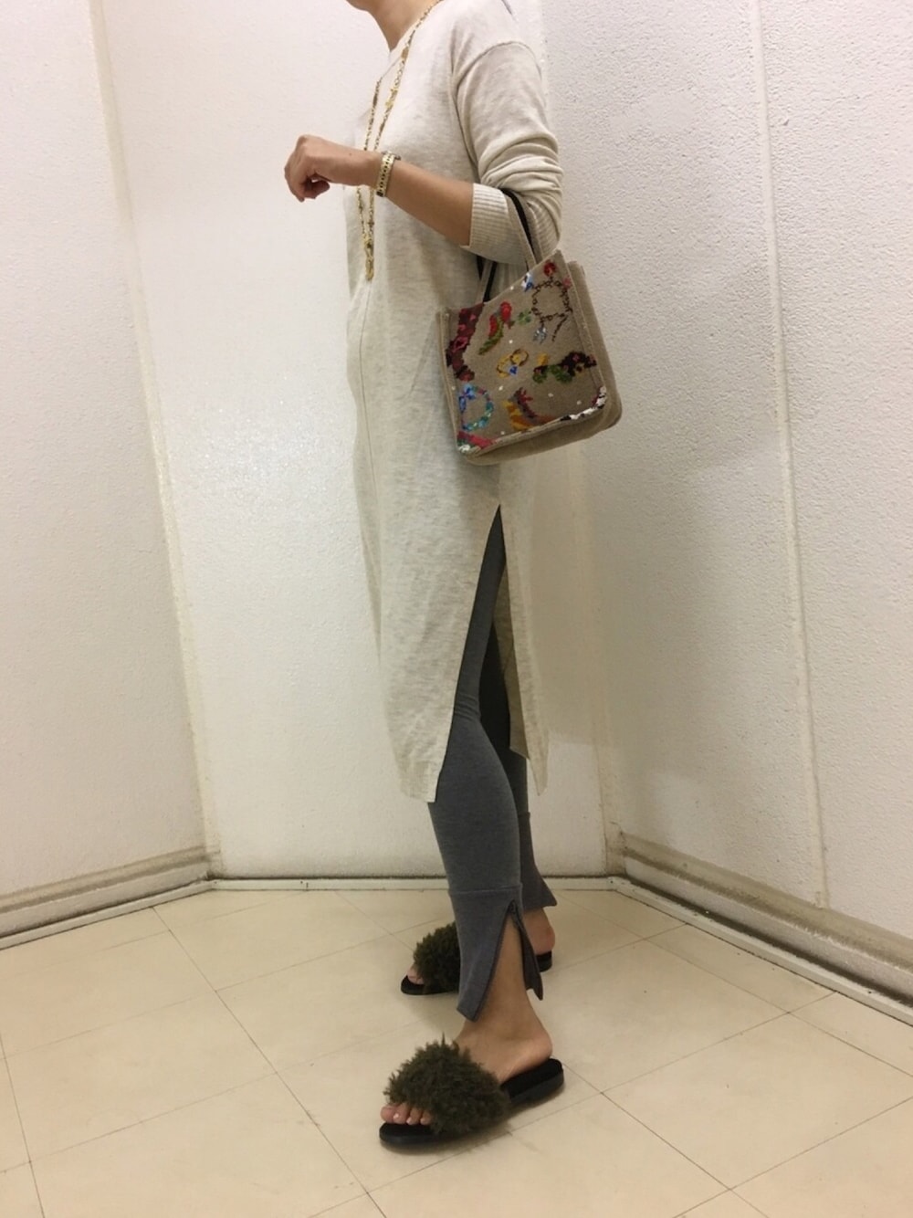 ベージュ系のワンピース、ブラウン系のハンドバッグ、グリーン系のスリッポンを着用したレディースの秋コーディネートの1枚目の写真