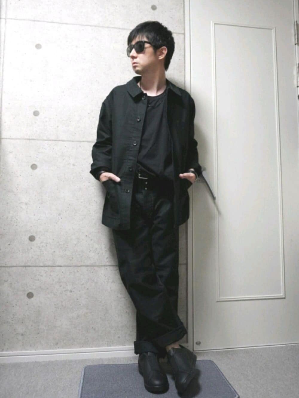 ブラック系のTシャツ/カットソー、ブラック系のチノパンツ、ブラック系のスニーカーを着用したメンズの秋コーディネートの1枚目の写真
