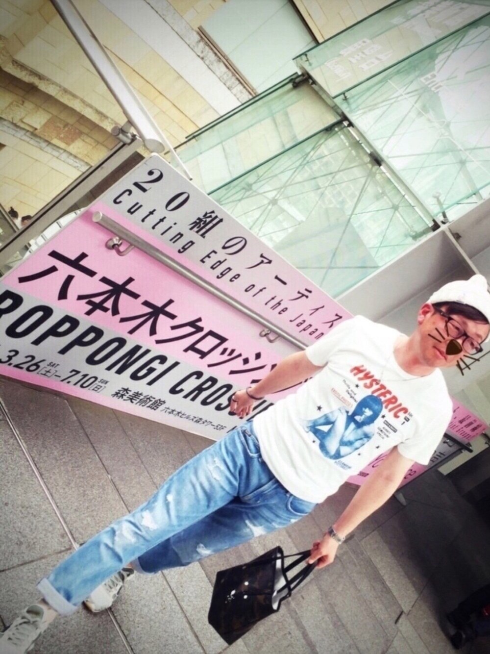 ホワイト系のTシャツ/カットソー、ブルー系のデニムパンツ、グリーン系のトートバッグを着用したメンズの春コーディネートの1枚目の写真