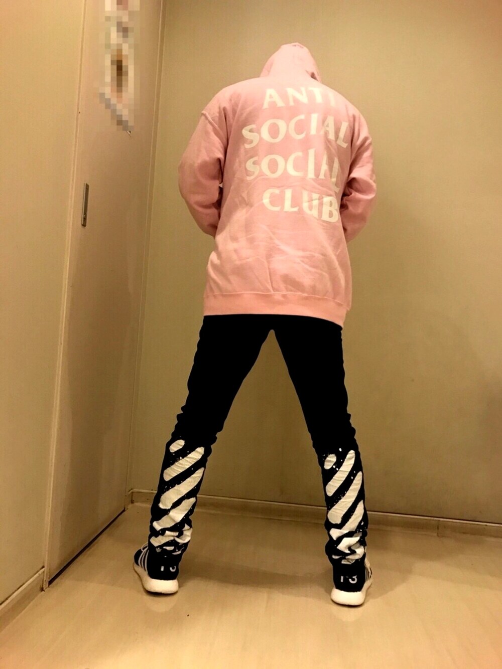 ピンク系のパーカー、ブラック系のデニムパンツ、ブラック系のスニーカーを着用したメンズの春コーディネートの1枚目の写真
