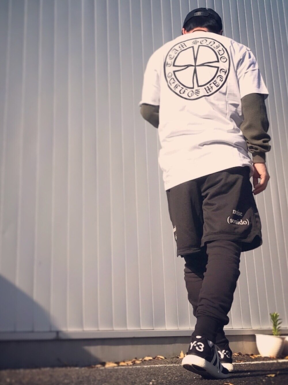 ホワイト系のTシャツ/カットソー、グリーン系のTシャツ/カットソー、ブラック系のパンツを着用したメンズの春コーディネートの1枚目の写真