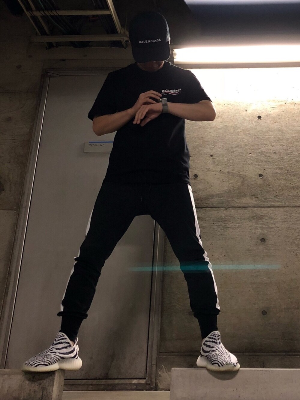 ブラック系のTシャツ/カットソー、ブラック系のその他パンツ、ホワイト系のスニーカーを着用したメンズの秋コーディネートの1枚目の写真