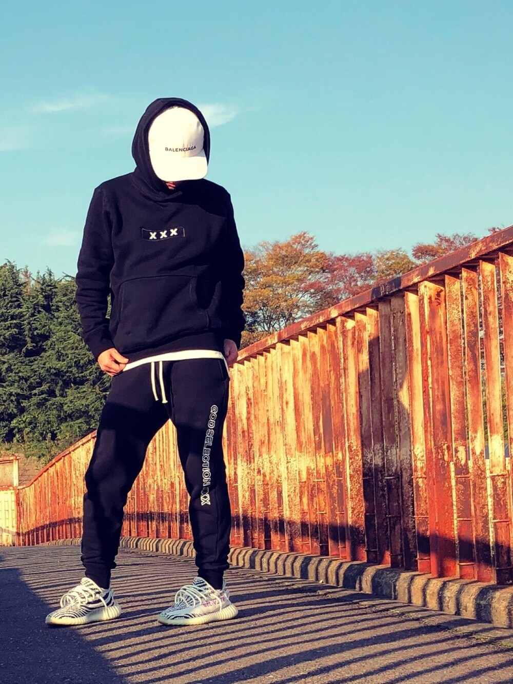ブラック系のパーカー、ブラック系のその他パンツ、ホワイト系のスニーカーを着用したメンズの秋コーディネートの1枚目の写真