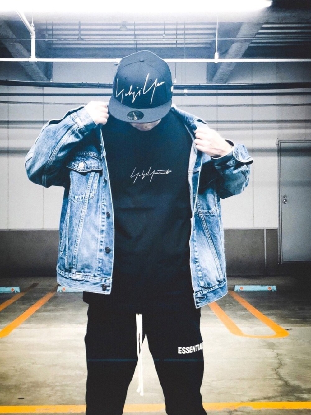 ブルー系のデニムジャケット、ブラック系のTシャツ/カットソー、ブラック系のスウェットパンツを着用したメンズの冬コーディネートの1枚目の写真