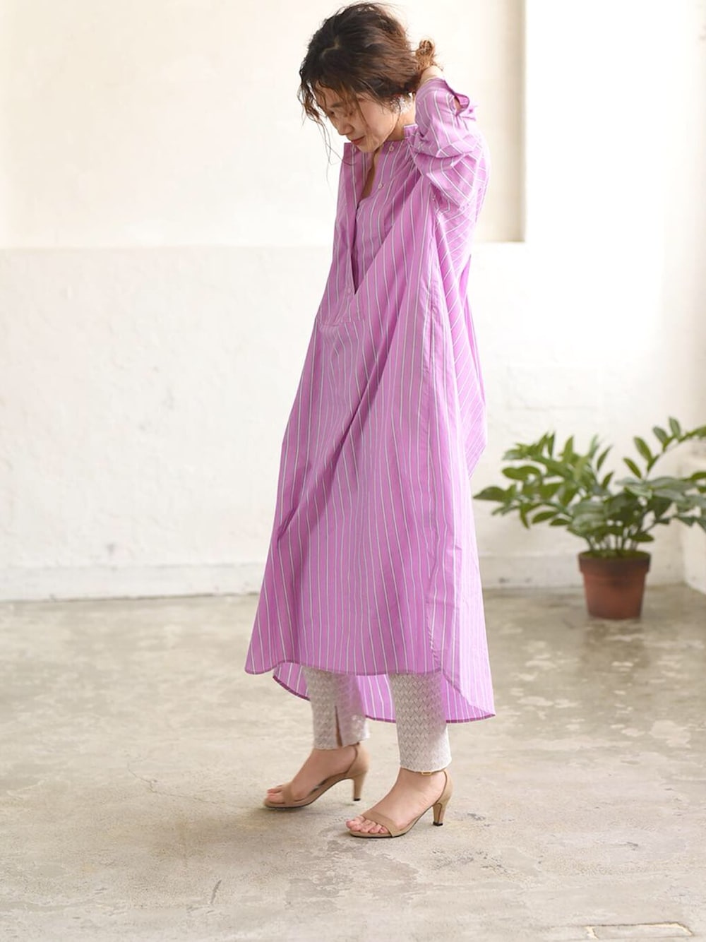 ピンク系のシャツワンピース、グレー系のレギンス/スパッツを着用したレディースの冬コーディネートの1枚目の写真