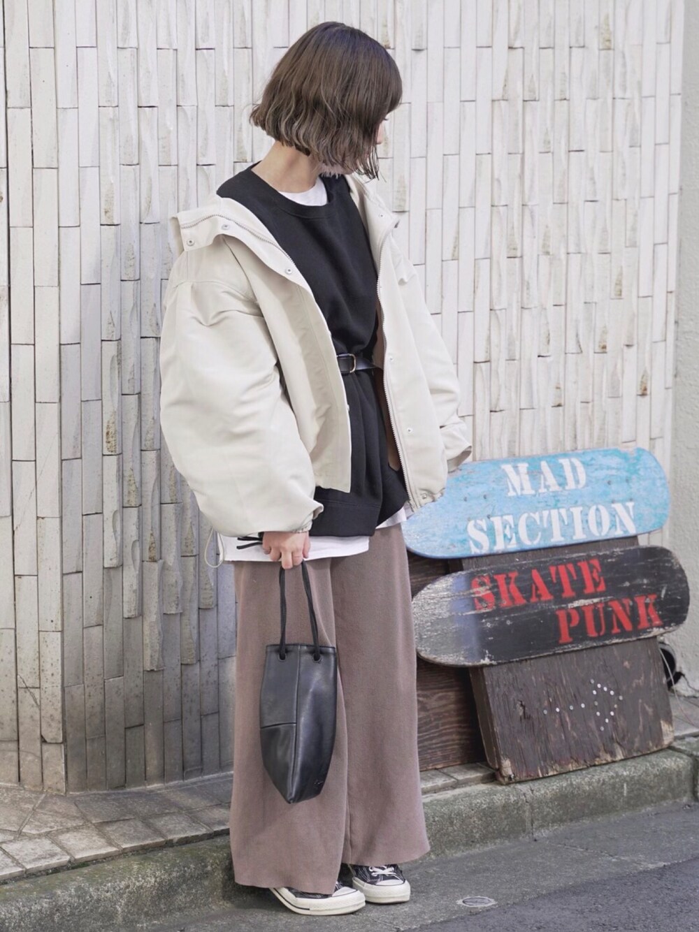 ベージュ系のマウンテンパーカー、ブラック系のスウェット、ベージュ系のその他パンツを着用したレディースの春コーディネートの1枚目の写真