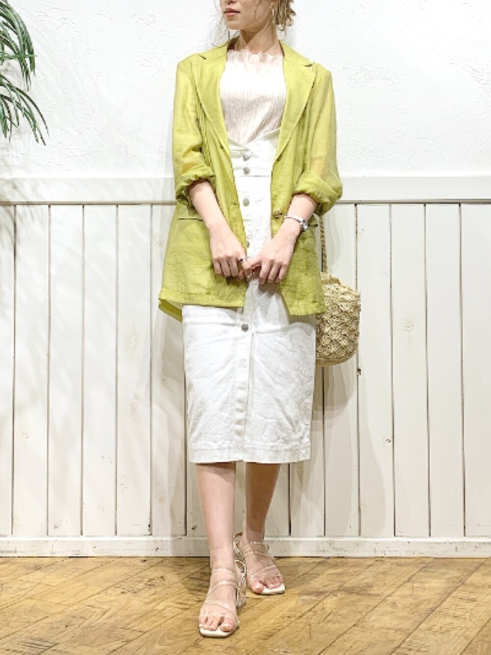 グリーン系のテーラードジャケット、ホワイト系のデニムスカート、その他のサンダルを着用したレディースの春コーディネートの1枚目の写真