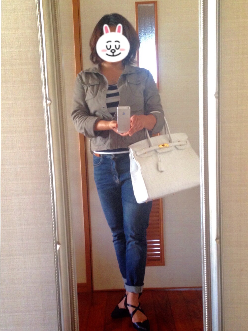 ホワイト系のハンドバッグ、ブラック系のパンプス、ホワイト系のTシャツ/カットソーを着用したレディースの春コーディネートの1枚目の写真