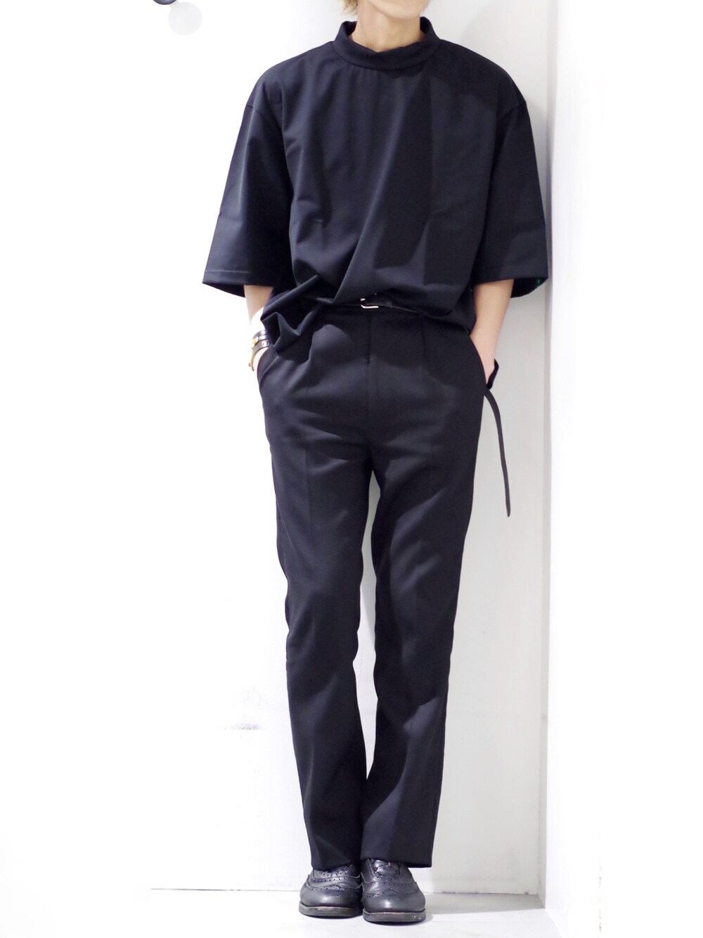 ブラック系のTシャツ/カットソー、ブラック系のスラックス、ブラック系のベルトを着用したメンズの春コーディネートの1枚目の写真