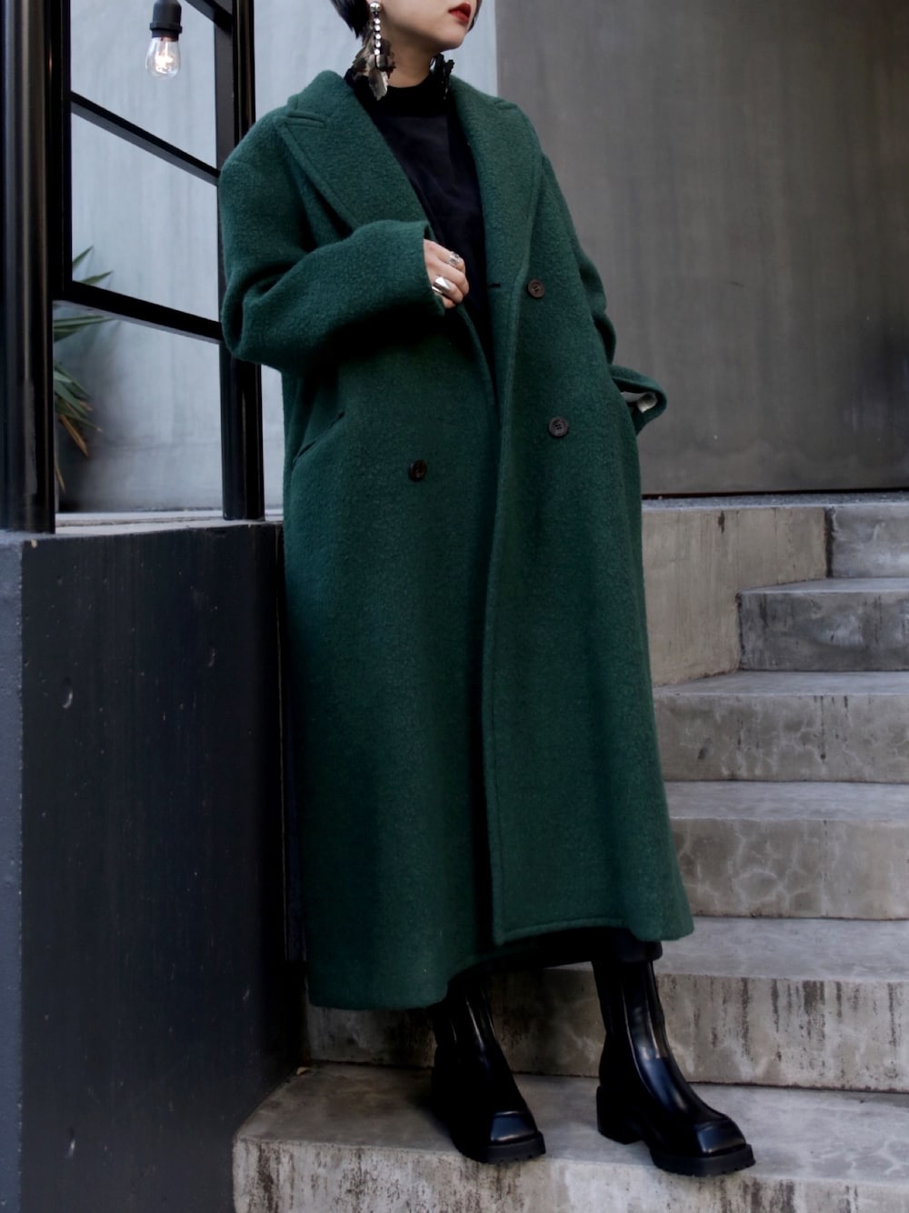 ブラック系のTシャツ/カットソー、グリーン系のジャケット/アウター、ブラック系のブーツを着用したレディースの冬コーディネートの1枚目の写真