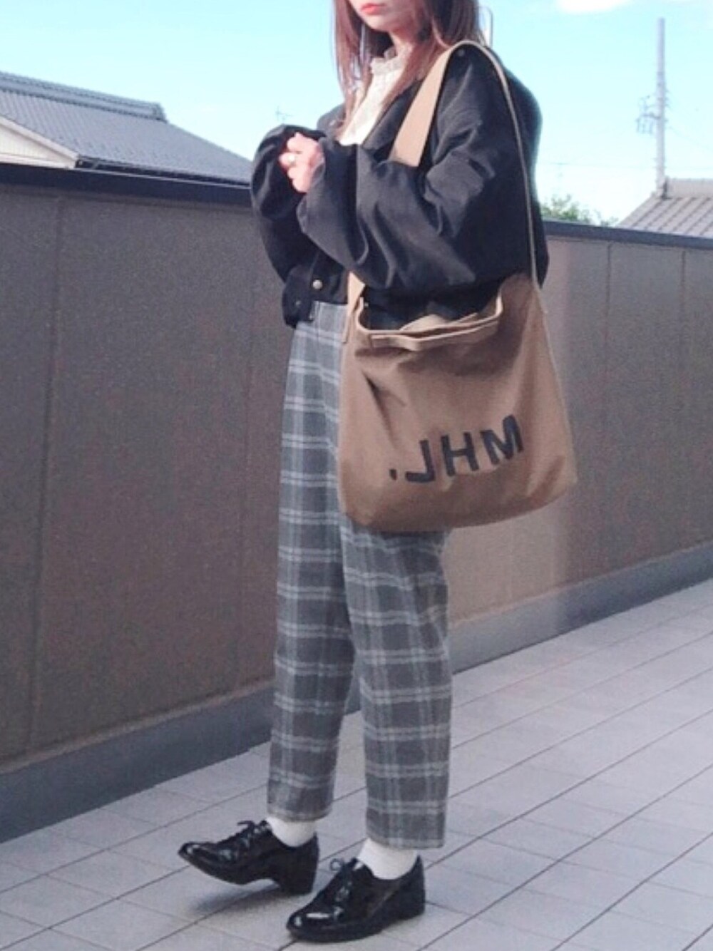 ブラック系のブルゾン、グレー系のその他パンツ、ホワイト系のシャツ/ブラウスを着用したレディースの秋コーディネートの1枚目の写真