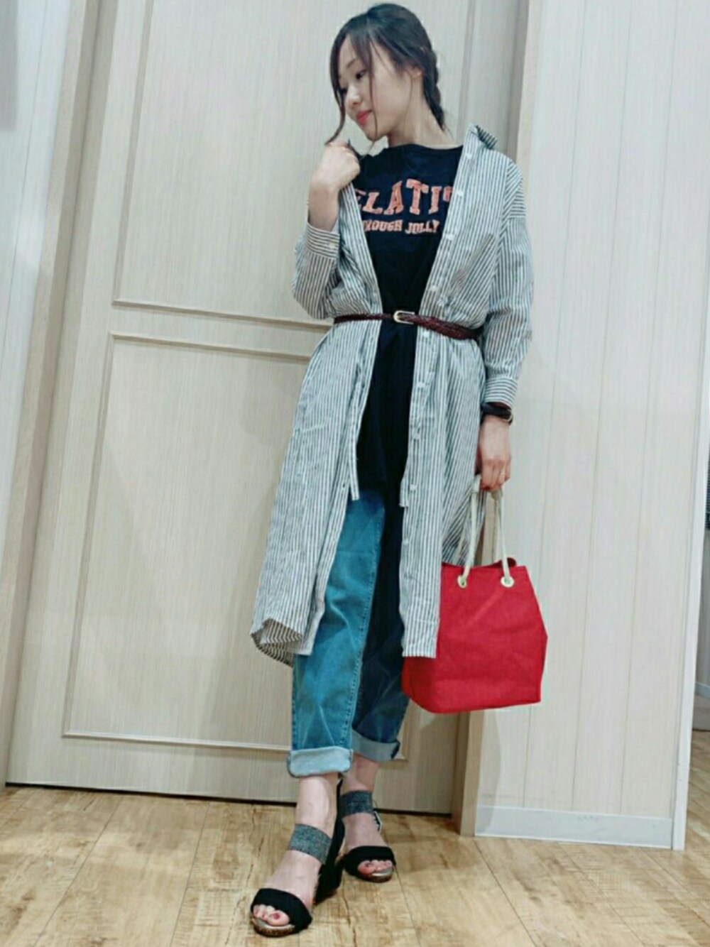 オレンジ系のトートバッグ、ブラック系のサンダル、ブルー系のデニムパンツを着用したレディースの夏コーディネートの1枚目の写真