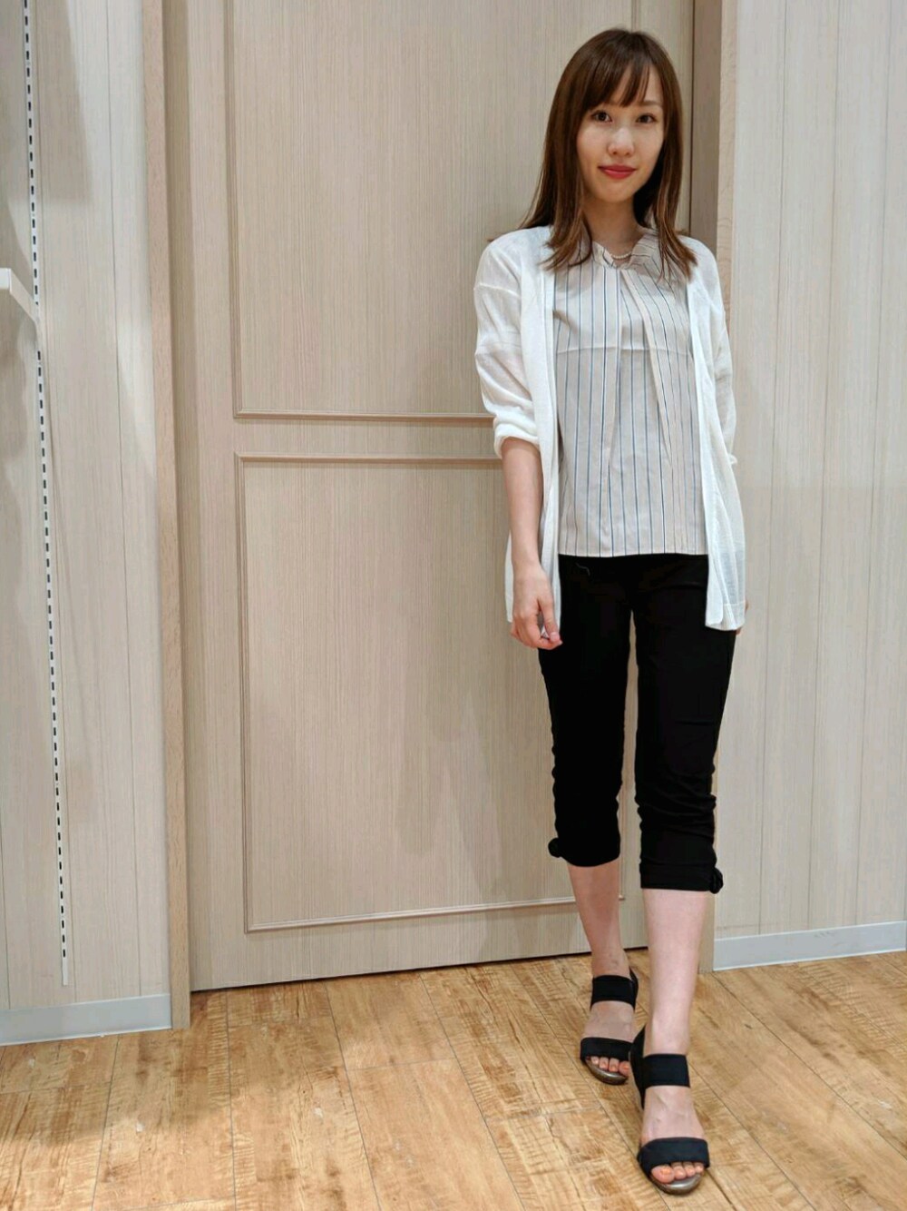 ベージュ系のシャツ/ブラウス、ブラック系のサンダル、ホワイト系のカーディガン/ボレロを着用したレディースの夏コーディネートの1枚目の写真