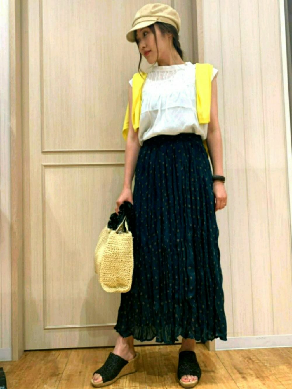 イエロー系のカーディガン/ボレロ、ホワイト系のシャツ/ブラウス、ブラック系のサンダルを着用したレディースの夏コーディネートの1枚目の写真