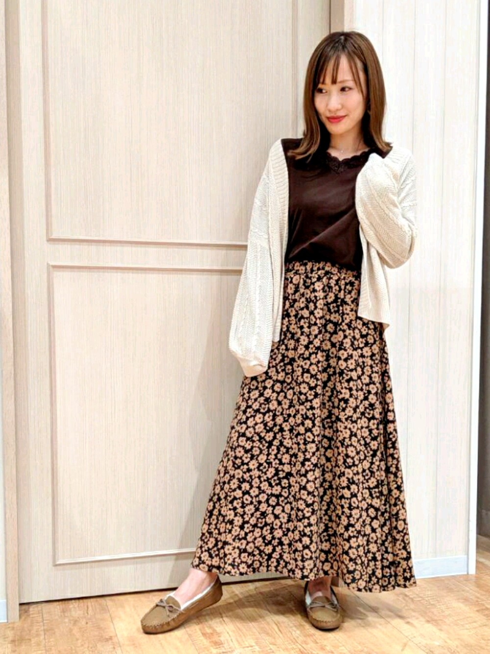 ブラウン系のトップス、ベージュ系のカーディガン/ボレロ、ベージュ系のシューズを着用したレディースの秋コーディネートの1枚目の写真