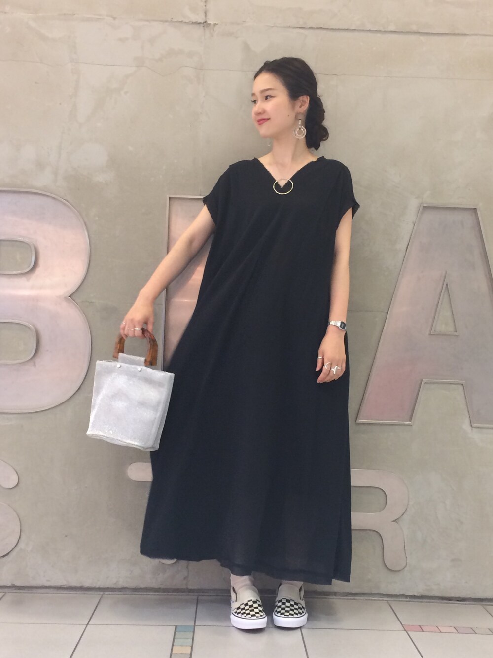 ブラック系のワンピース、シルバー系のバッグ、その他のスニーカーを着用したレディースの夏コーディネートの1枚目の写真