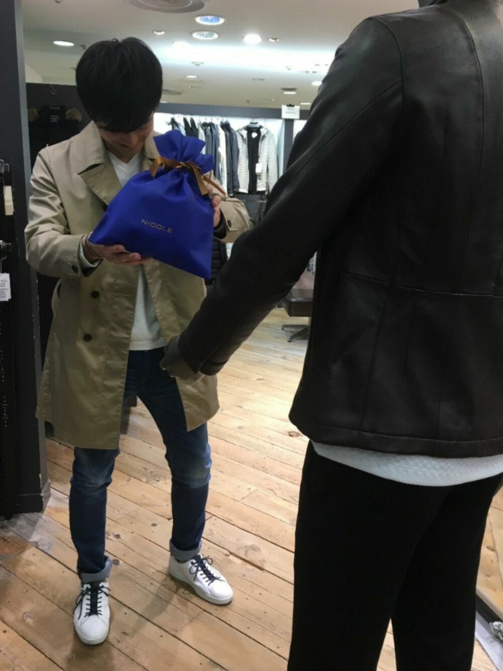 ベージュ系のジャケット/アウター、ブルー系のデニムパンツ、ホワイト系のスニーカーを着用したメンズの冬コーディネートの1枚目の写真