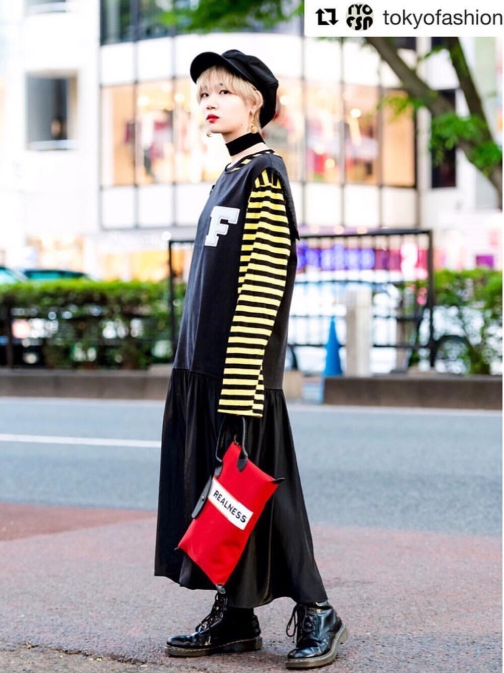イエロー系のTシャツ/カットソー、レッド系のクラッチバッグ、ブラック系のブーツを着用したレディースの冬コーディネートの1枚目の写真