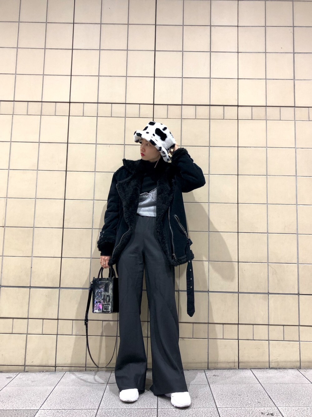 ブラック系のパンツ、ブラック系のショルダーバッグ、ホワイト系のスニーカーを着用したレディースの冬コーディネートの1枚目の写真