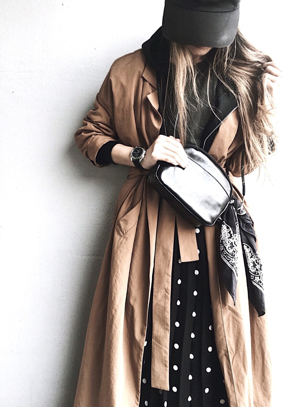 ブラック系のパーカー、ブラック系のスカート、ブラック系のショルダーバッグを着用したレディースの春コーディネートの1枚目の写真