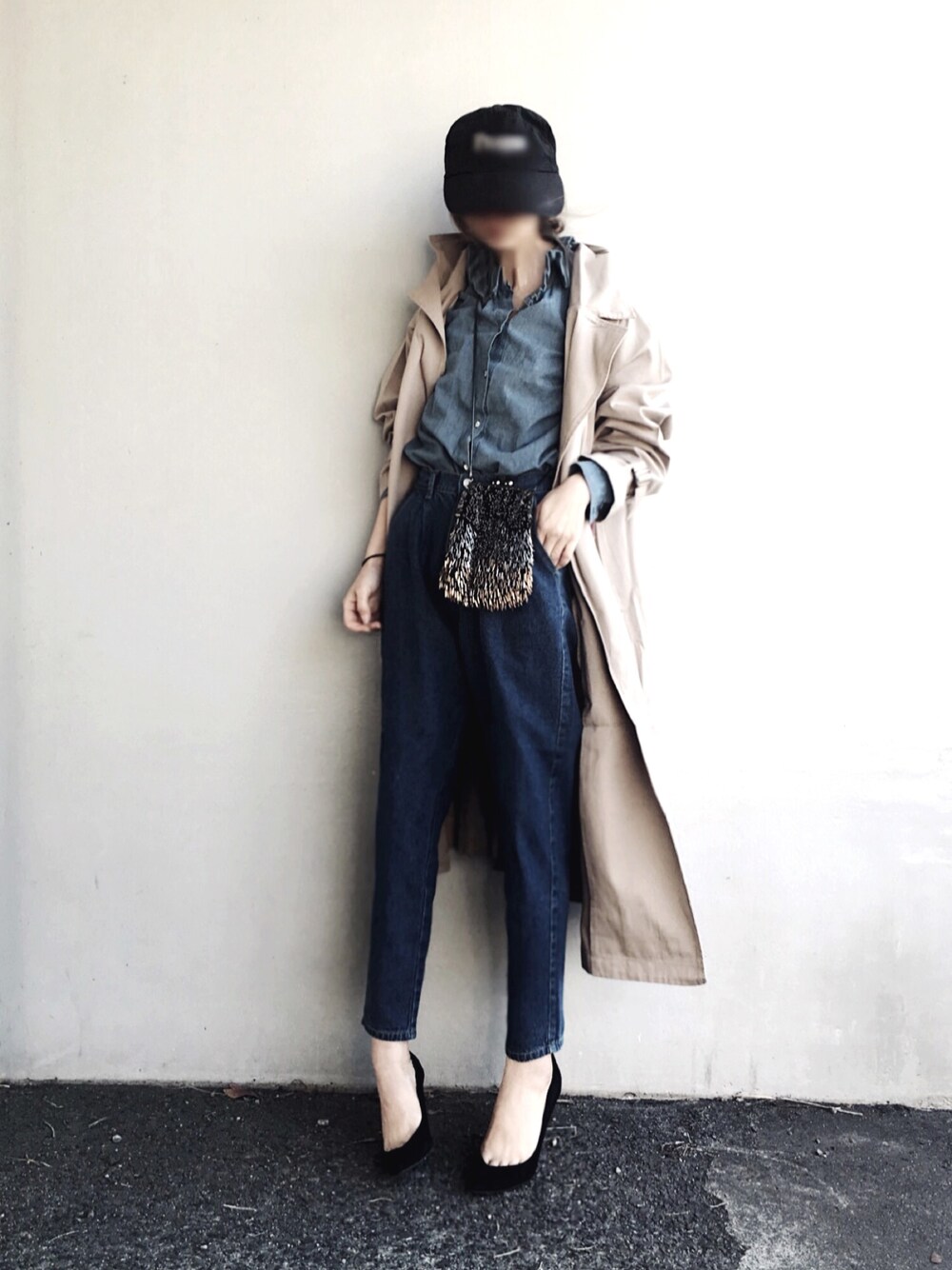 ベージュ系のトレンチコート、ブルー系のデニムパンツを着用したレディースの春コーディネートの1枚目の写真