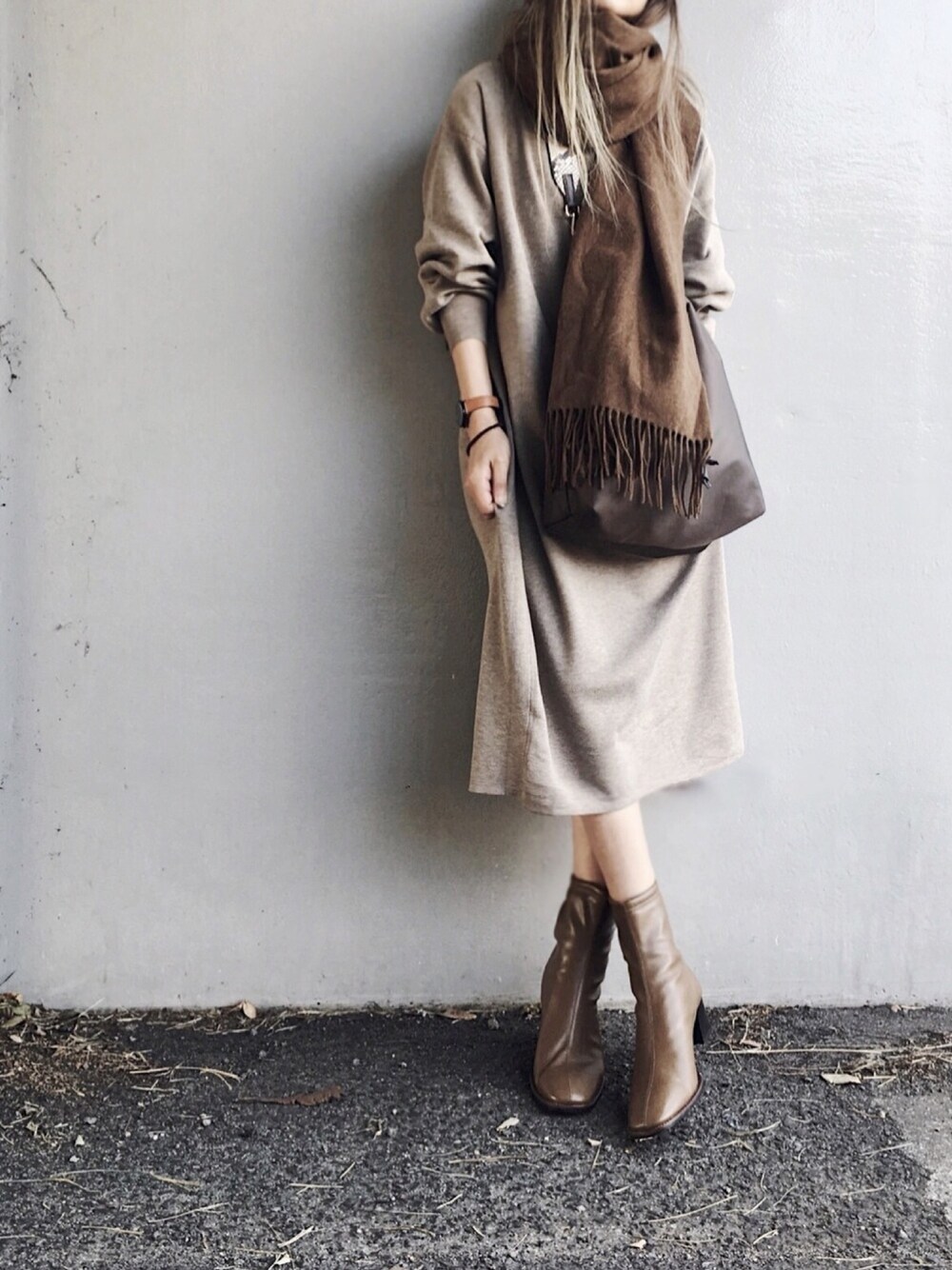 ベージュ系のワンピース、グリーン系のトートバッグ、ブラウン系のブーツを着用したレディースの秋コーディネートの1枚目の写真