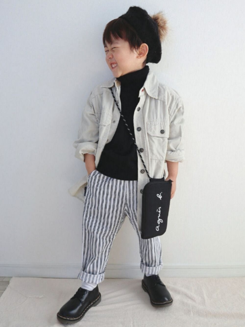 ホワイト系のシャツ/ブラウス、ブラック系のニット/セーター、ブラック系のショルダーバッグを着用したキッズの春コーディネートの1枚目の写真