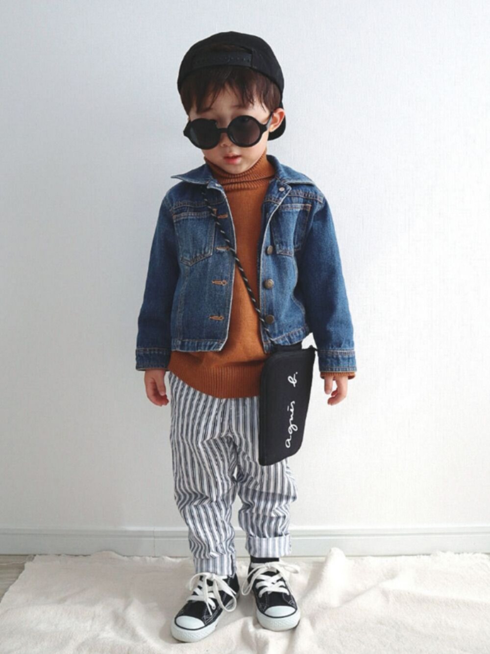 ブルー系のデニムジャケット、イエロー系のニット/セーター、ホワイト系のその他パンツを着用したキッズの春コーディネートの1枚目の写真
