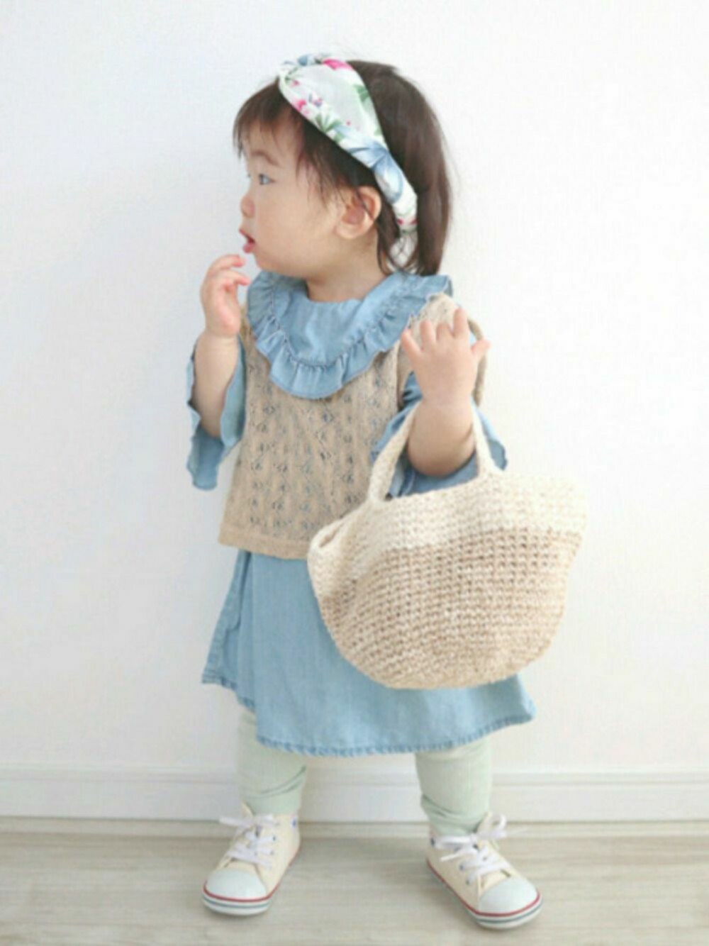 ベージュ系のチュニック、ベージュ系のかごバッグ、ブルー系のワンピースを着用したキッズの春コーディネートの1枚目の写真
