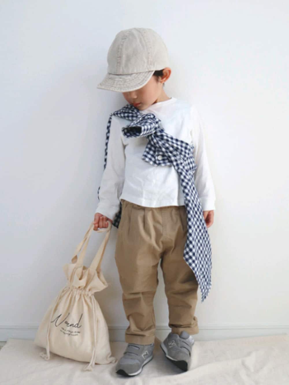 ベージュ系のハンドバッグ、ベージュ系のその他パンツ、ホワイト系のTシャツ/カットソーを着用したキッズの春コーディネートの1枚目の写真