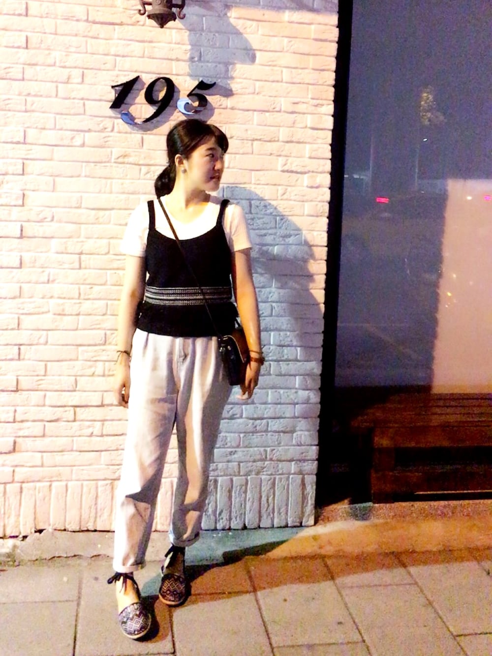 ブラック系のトップス、ブルー系のデニムパンツ、ブラック系のシューズを着用したレディースの春コーディネートの1枚目の写真