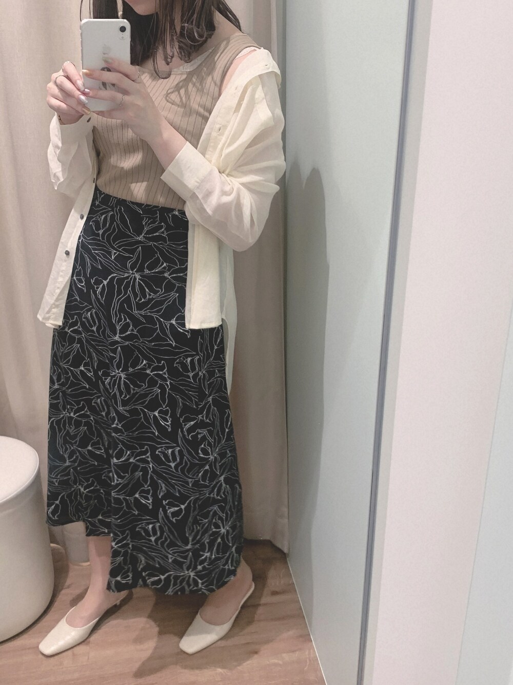 ホワイト系のシャツ/ブラウス、ベージュ系のタンクトップ、ブラック系のスカートを着用したレディースの春コーディネートの1枚目の写真